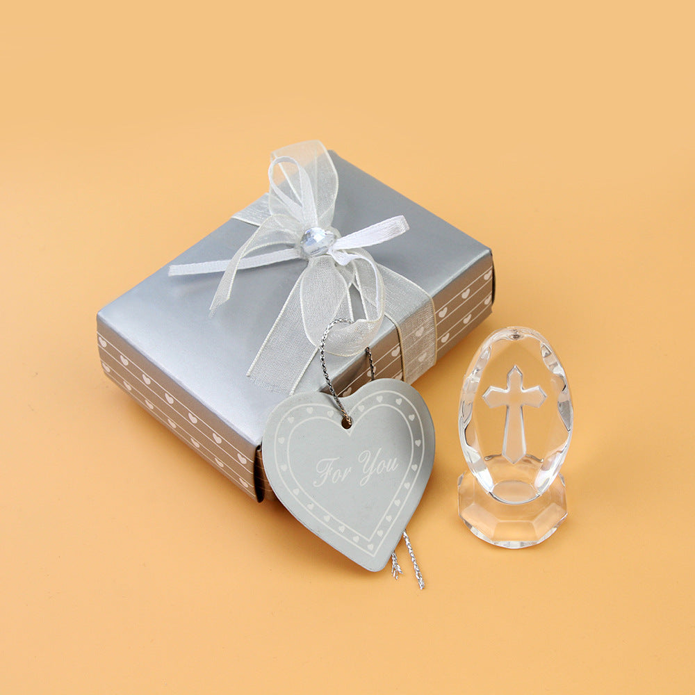 Decorative heart-shaped tag and clear crystal figurine on a beige background