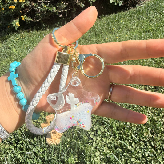 Hand holding a keychain with a clear cross keychain