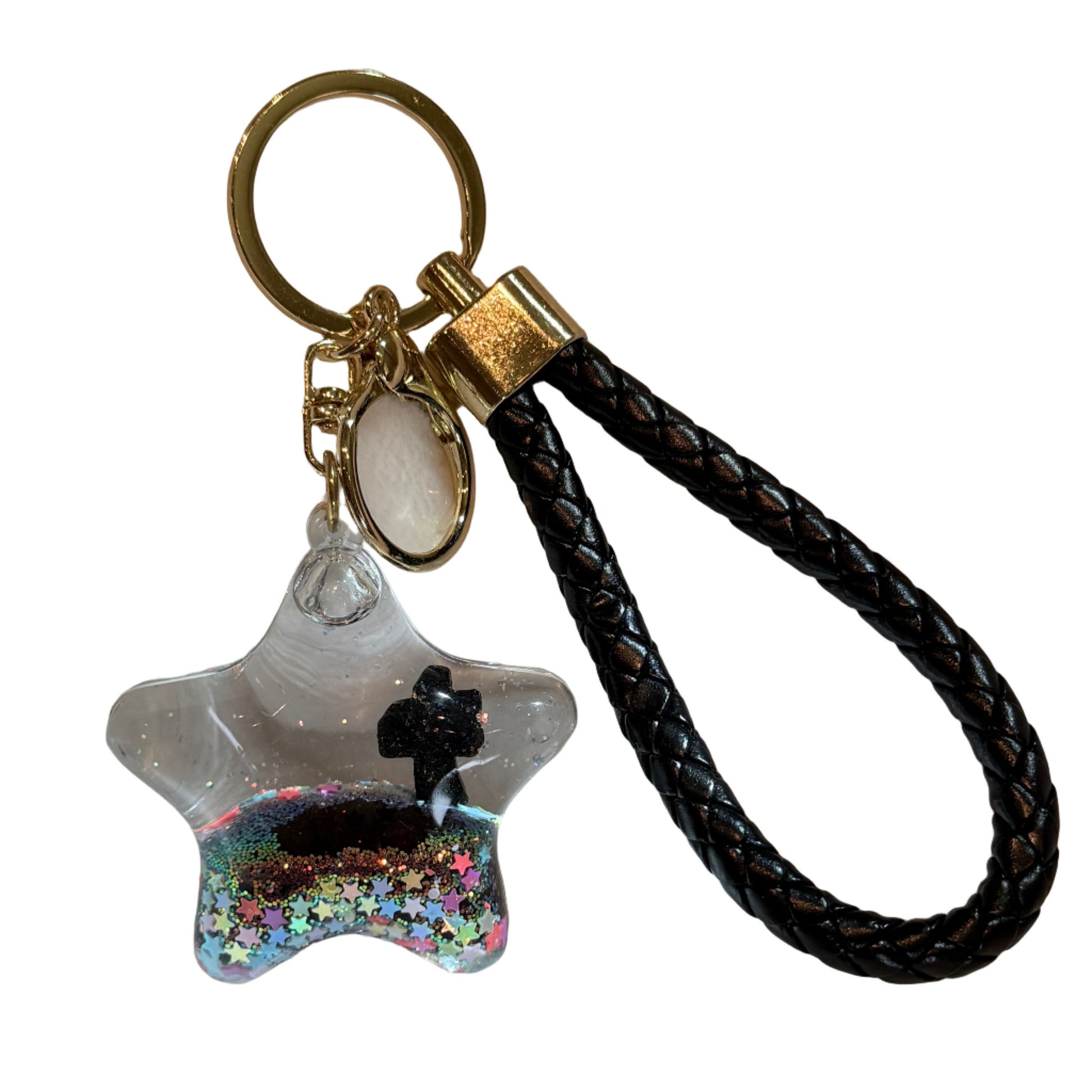 Keychain with black braided strap and clear bag with colorful glittery charm on a white surface